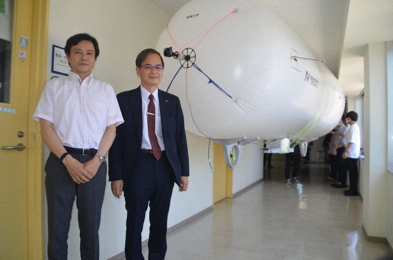 飛行船型の無人調査ロボット「トンネルマンボウ」(中央奥)を開発した山本副学長(左から2人目)