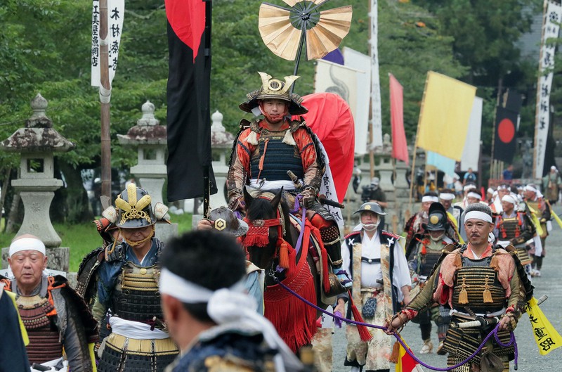 見物客を入れずに奉上祭や出陣式のみを行い、相馬中村神社の参道を練り歩く相馬行胤(みちたね)さん(中央)ら=福島県相馬市で2020年7月25日午前9時55分、和田大典撮影