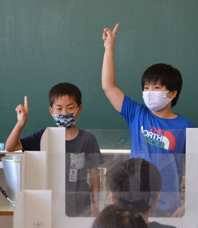 飛まつガードを立て、給食の時間に手話を学ぶ子供たち=大分県別府市立亀川小で2020年7月17日午後0時39分、大島透撮影