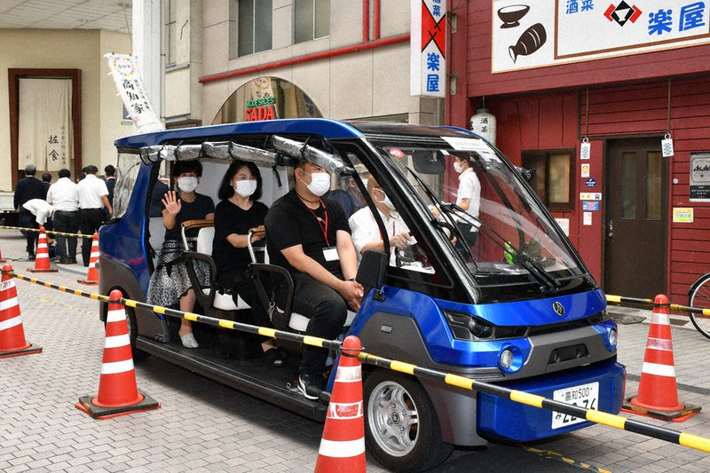 市民らを乗せて商店街を走行する自動運転車両=高知県四万十市中村天神橋で