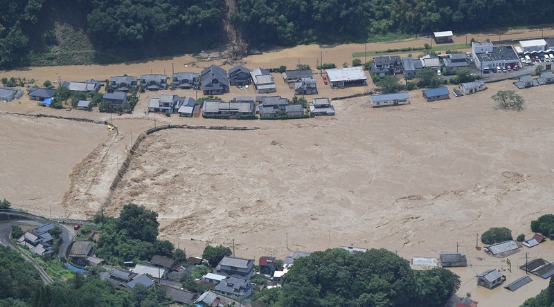 球磨川が氾濫し浸水した住宅。川の流域にあり、命へ危険を及ぼす可能性が高いエリアにある住宅は今後、安全な地域への移転も促される=熊本県球磨村で2020年7月4日午前11時43分、本社ヘリから田鍋公也撮影