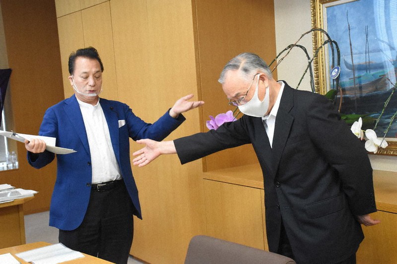 千代田区の石川雅巳区長(右)は解散の通知(左下)を受け取るよう促すが、小林孝也議長は受け取りを拒んだ=千代田区で