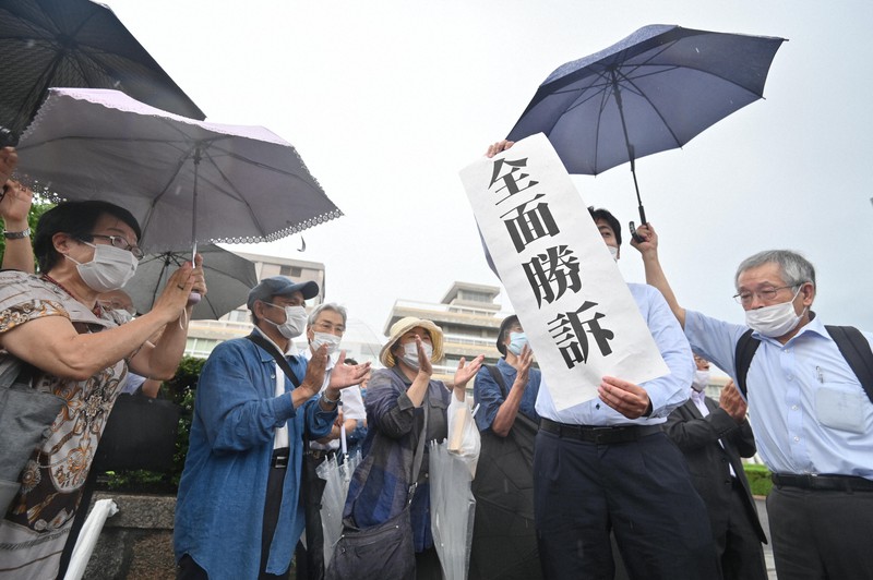 被爆者健康手帳の交付を求めた訴訟で、全面勝訴の紙を掲げる弁護士=広島市中区で2020年7月29日午後2時7分、山田尚弘撮影