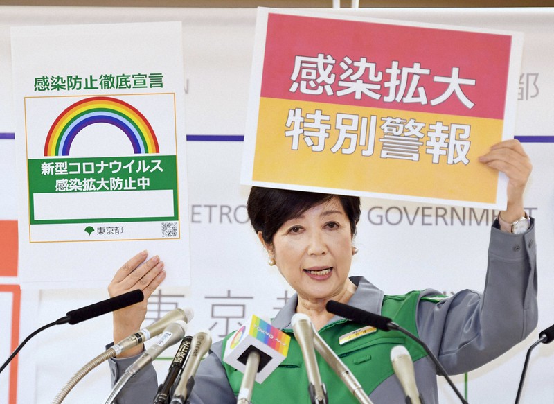 記者会見で啓発パネル2枚を掲げて警戒を呼びかける小池百合子東京都知事=東京都庁で2020年7月30日午後5時32分、滝川大貴撮影