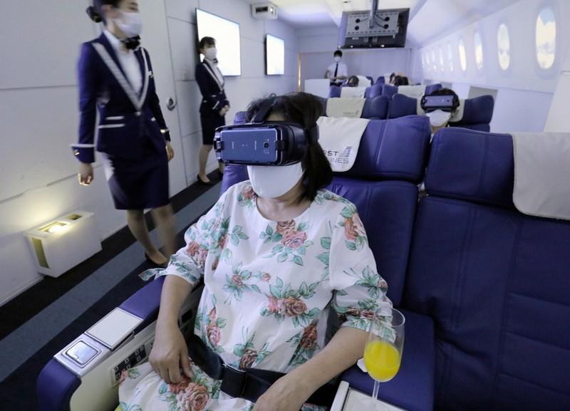 VRゴーグルを装着して海外旅行の気分を味わう利用者ら=東京都豊島区で2020年7月3日、宮武祐希撮影