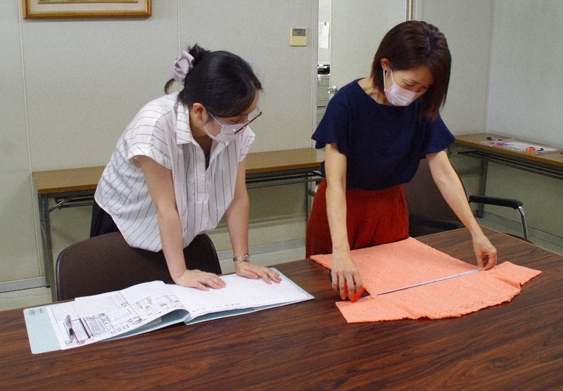 ニットの検品をする川村美恵さん(右)。希望のアパレルに就職できた=埼玉県川口市の太陽毛絲紡績で