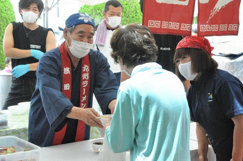 ラーメンを手渡す九州ラーメン党の濱田理事長(左から2人目)