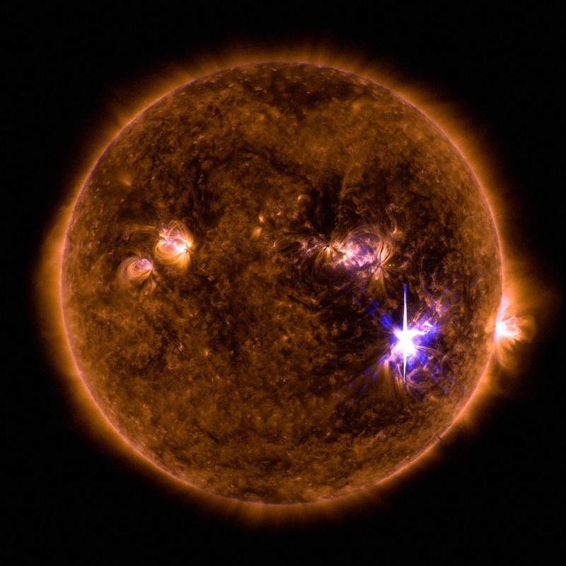 米航空宇宙局(NASA)の太陽観測衛星が捉えた太陽フレア(右下)。特殊な光で撮影しているため実際の色とは異なる=NASA提供