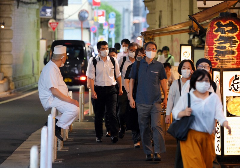 ガード下の居酒屋の前を通り、マスクを着けて足早に新橋駅方面に向かう人たち=東京都港区で2020年7月31日午後6時8分、手塚耕一郎撮影