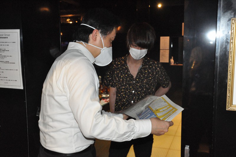 新宿・歌舞伎町のホストクラブで感染防止を呼びかける吉住健一区長(左)=新宿区提供