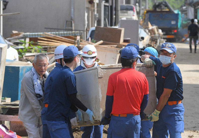 孤立状態が解消し、消防団員らと災害ごみの搬出をする白石地区の住民(左)=熊本県芦北町で2020年8月1日午前9時14分、津村豊和撮影