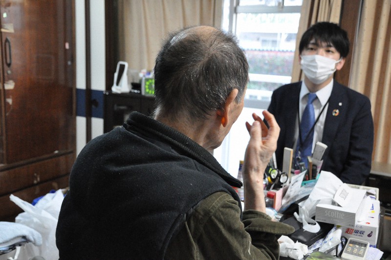 自身が亡くなった後の手続きに関する契約を結んだ男性(左)。右は三井住友信託銀行の担当者=東京都内の男性の自宅で2020年3月11日、三上剛輝撮影
