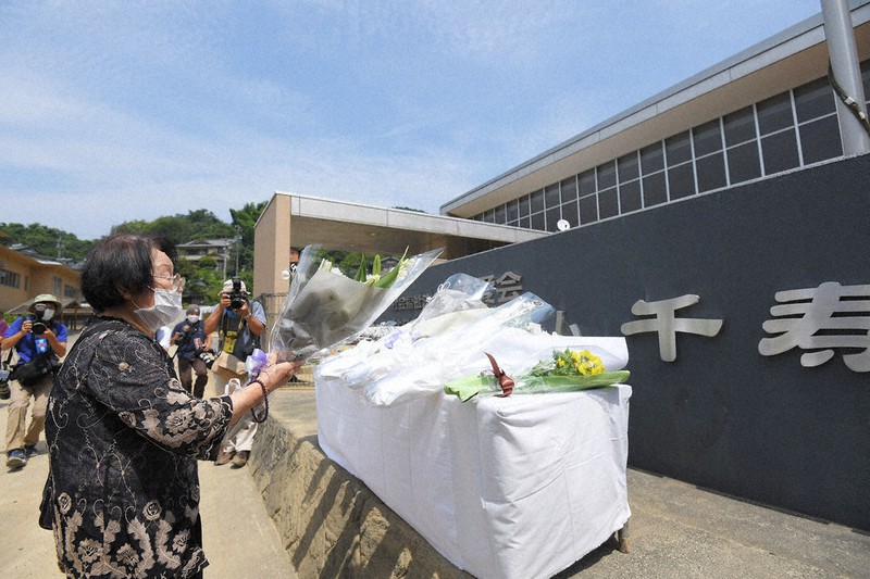 九州豪雨から1カ月になるのを前に、千寿園の前で犠牲者を悼む遺族=熊本県球磨村で3日、津村豊和撮影