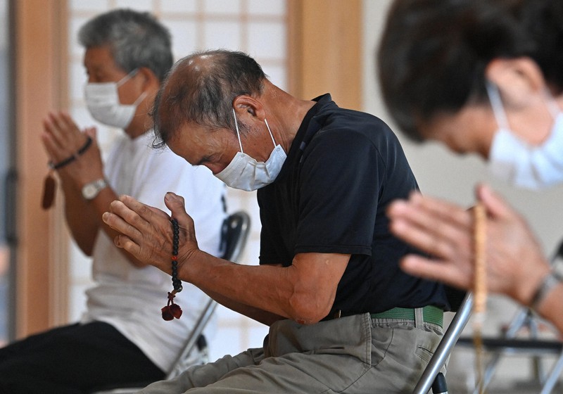 山本レイ子さんの法要で手を合わせる夫の守さん(中央)=熊本県芦北町で2020年8月4日午前9時2分、徳野仁子撮影