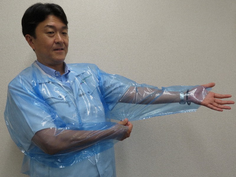 カワシマが製造した医療用の使い捨てガウンを着てみせる川島謙一社長=名古屋市中村区で、田口雅士撮影