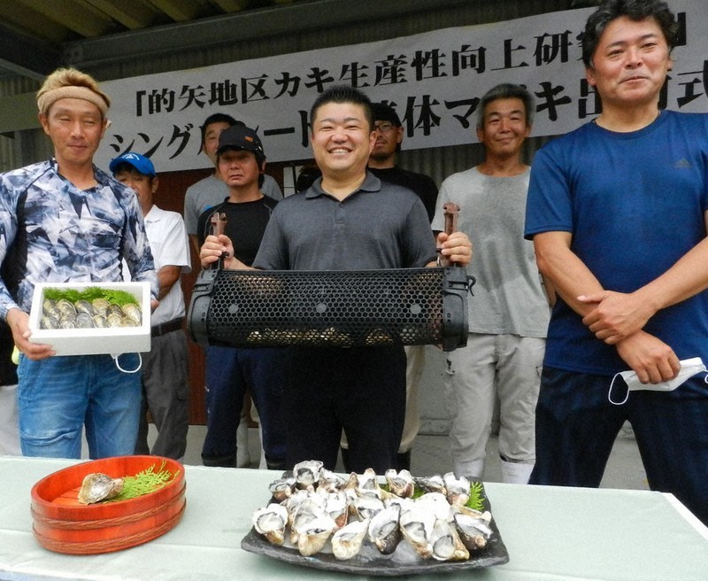 3倍体のマガキを手に初出荷を喜ぶカキ養殖漁業者=三重県志摩市磯部町的矢で2020年8月4日午前10時7分、林一茂撮影