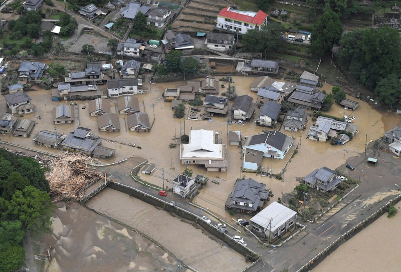 球磨川と支流の川内川(左下)の氾濫で避難所に指定されていた神瀬多目的集会施設(中央の白い屋根)は水没した=熊本県球磨村で2020年7月4日午後4時18分、本社ヘリから田鍋公也撮影