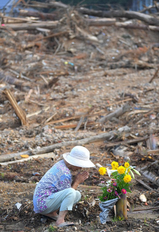 土砂崩れで住民が犠牲になった現場で手を合わせる近所の女性=熊本県芦北町で4日、津村豊和撮影
