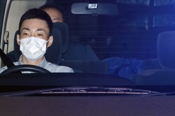 顔を伏せたまま送検される容疑者（右）＝京都市中京区で2020年7月24日、久保玲撮影
