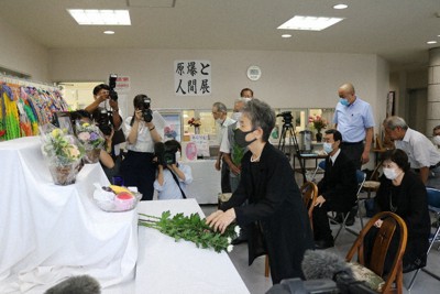 献花台に菊を手向け、恒久平和を祈る参列者