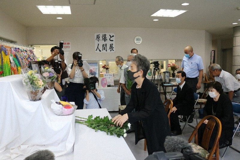 献花台に菊を手向け、恒久平和を祈る参列者