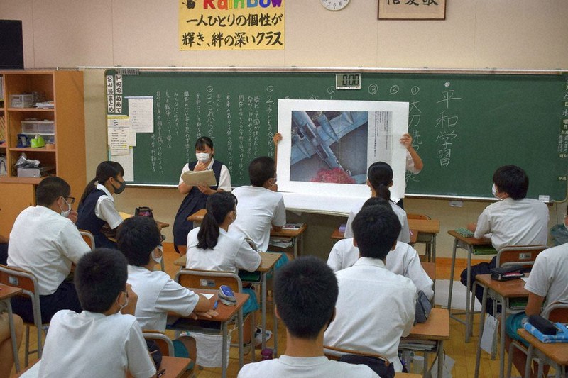 絵本「シイの木はよみがえった」の紙芝居の読み聞かせに見入る生徒たち