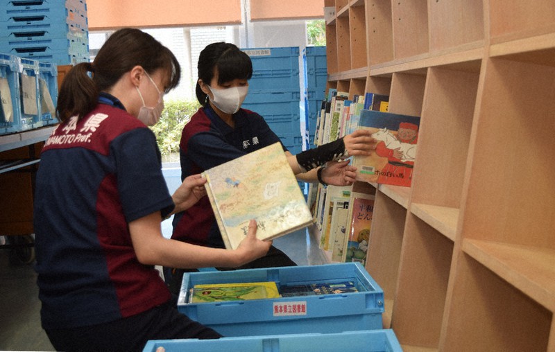 熊本県芦北町の臨時図書館の開設に向け児童書などの搬入に追われる県立図書館の職員ら