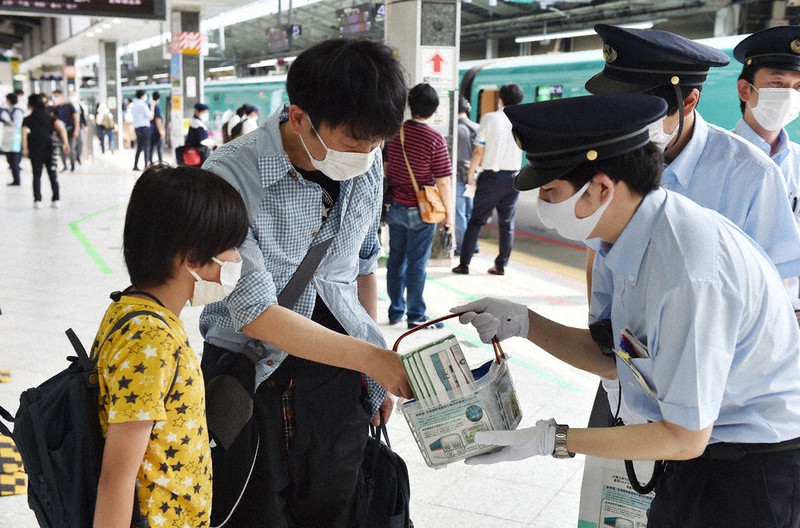 新型コロナウイルス感染防止のため、新幹線のホームでは利用客に除菌用シートが配られた=JR東京駅で8日午前8時48分、滝川大貴撮影
