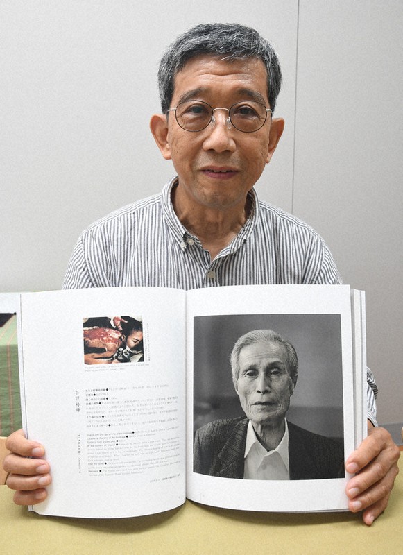 長崎原爆をテーマにした3作目の写真集を手にする写真家の松村さん