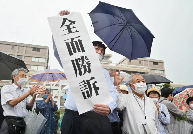 被爆者健康手帳の交付を求めた訴訟で、全面勝訴の垂れ幕を掲げる原告団の弁護士=広島市中区で2020年7月29日午後2時7分、山田尚弘撮影