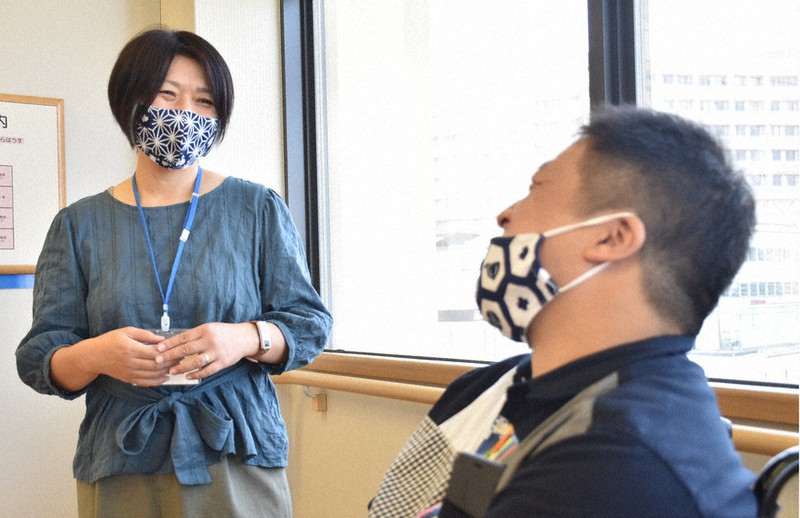 脳性まひのある男性(右)と話す坂本彩さん=大津市馬場2のやまびこ総合支援センターで、小西雄介撮影