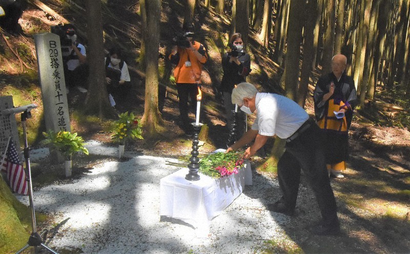 石碑の前に献花する参列者ら=三重県名張市青蓮寺のB29搭乗員追悼碑前で2020年8月15日午前10時18分、衛藤達生撮影