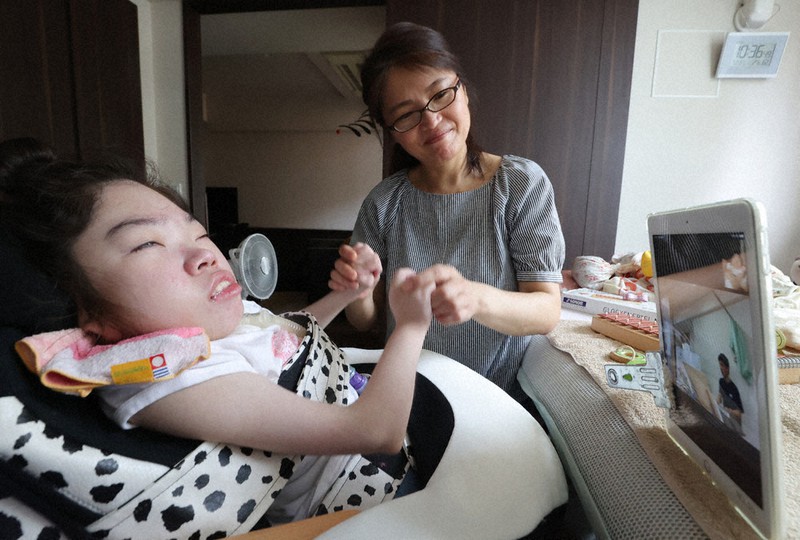 母明美さん(奥)に付き添われながら、オンラインで音楽の授業を受ける山根和々佳さん=東京都杉並区で2020年7月21日、喜屋武真之介撮影