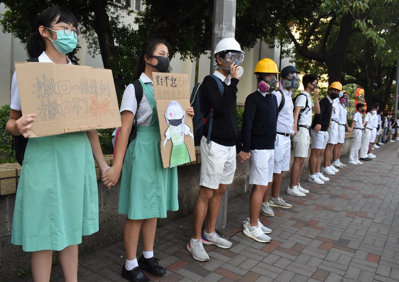学校の校門前で「人間の鎖」を作り、政府に抗議する中高生ら。香港の教育は若者の民主的な思考を養ってきたと言われる=香港中心部で2019年9月9日午前7時37分、福岡静哉撮影