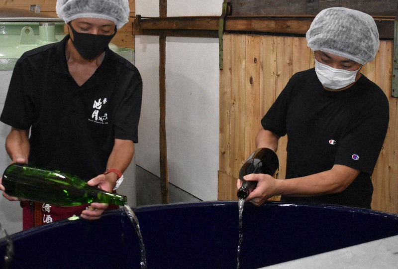 レンドする酒をタンクに注ぐ酒造会社の杜氏(とうじ)=島根県益田市中島町で、竹内之浩撮影