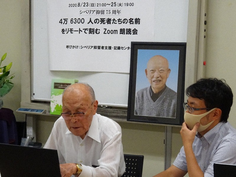 村山常雄さんの遺影の前でパソコンに向かって名簿を読む抑留経験者の西倉勝さん(95)=新宿区神楽河岸で
