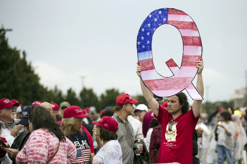 トランプ米大統領の支援集会への入場を待つ間「Q」を掲げる男性=米ペンシルベニア州で2020年8月2日、AP