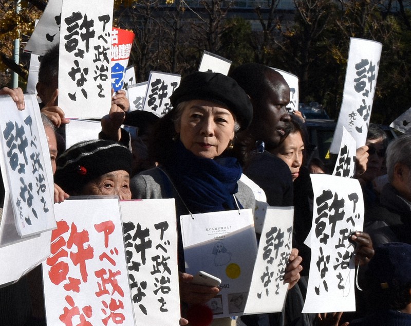 「アベ政治を許さない」と書かれたプラカードを掲げる木内みどりさん(中央)=東京・永田町の国会前で2019年1月3日、沢田石洋史撮影