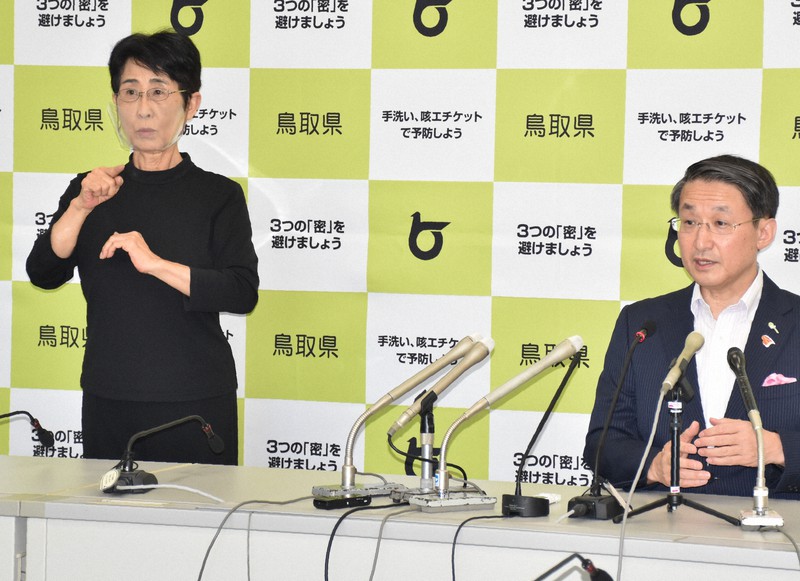 鳥取県の平井伸治知事(右)の記者会見に同席する手話通訳者=鳥取市の同県庁で2020年8月19日午前10時4分、阿部絢美撮影