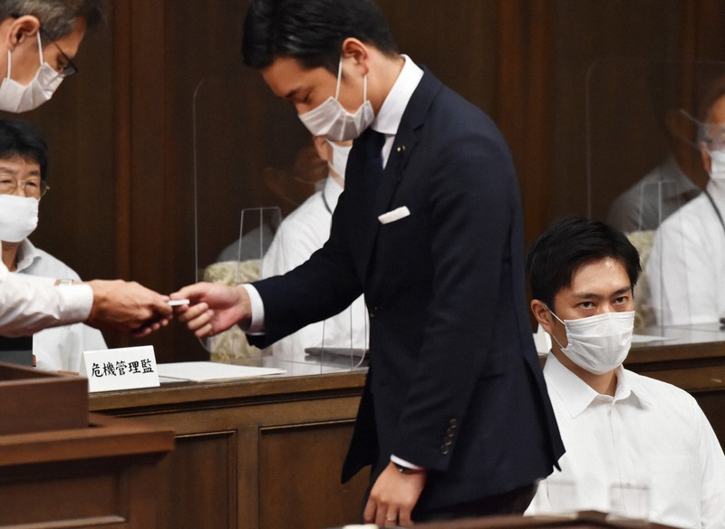 大阪都構想制度案の採決で賛成票を投じる自民党の原田亮・大阪府議(中央)。右は吉村洋文府知事=大阪市中央区で2020年8月28日午後1時25分、加古信志撮影