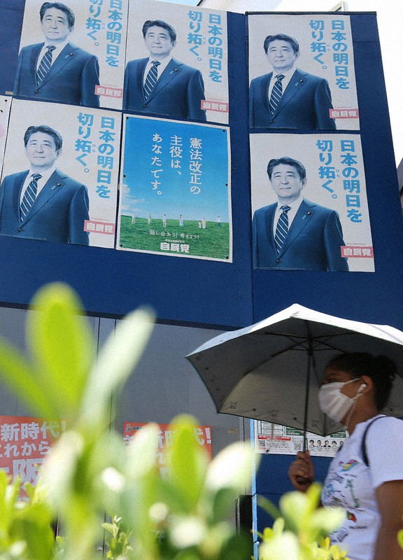 安倍晋三首相のポスターが張られた自民党大阪市議の事務所前を通り過ぎる人=大阪市西淀川区で2020年8月29日午前10時、小出洋平撮影