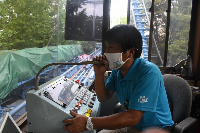 ジェットコースター「コークスクリュー」の発車前、「なるべく大声を出さないで」と乗客に注意を呼びかける渡辺孝一さん=東京都練馬区で2020年8月25日午後0時52分、井川諒太郎撮影