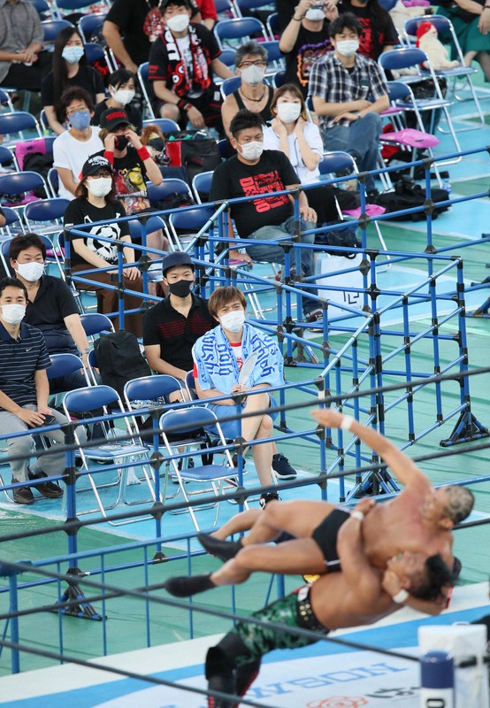 新型コロナウイルス対策でマスク姿で間隔をとって着席し、プロレスを楽しむ観客たち=神宮球場で2020年8月29日、山本晋撮影