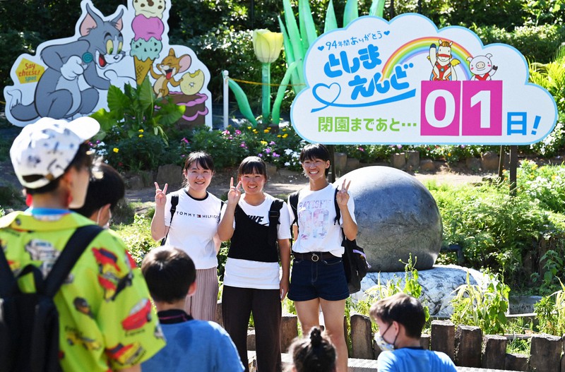 遊園地「としまえん」閉園を知らせる看板の前で記念撮影する来場者=東京都練馬区で2020年8月30日午後2時6分、大西岳彦撮影