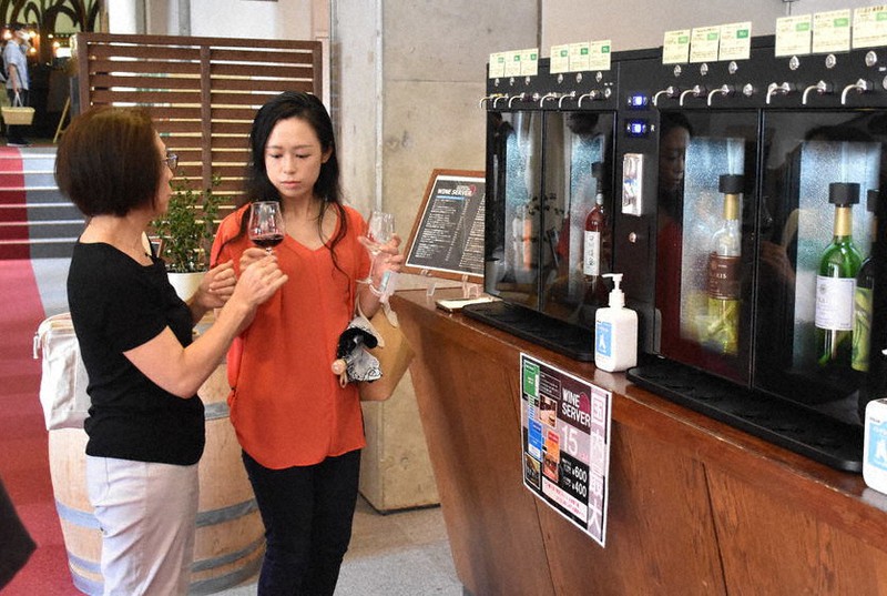 ワインサーバーで注いだワインを飲む来場者=山梨県甲州市で2020年8月30日、金子昇太撮影