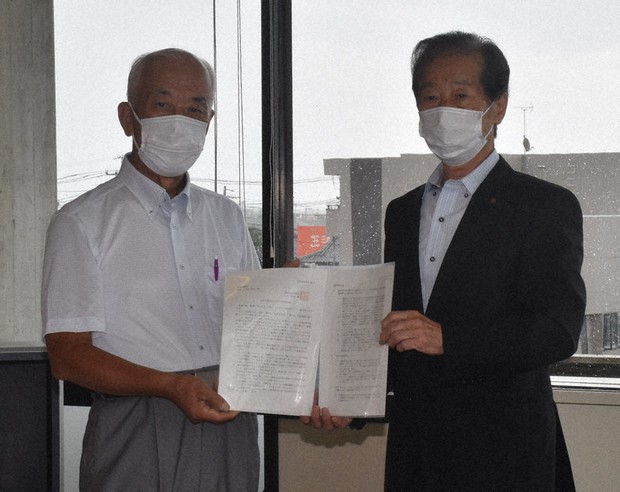 岐阜県羽島市議会の山田紘治議長(右)に公開質問状を手渡した味岡巌・市自治委員会長