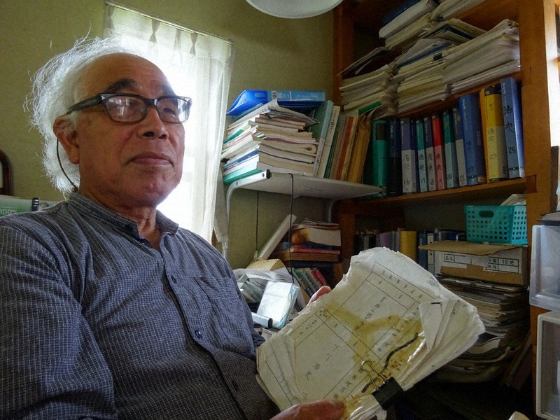 ぼろぼろになるまで読み込んだ実況見分調書を手にする下川正和さん=日の出町平井で