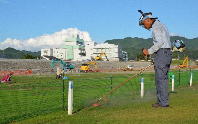 芝の手入れや草取りをする地元住民ら