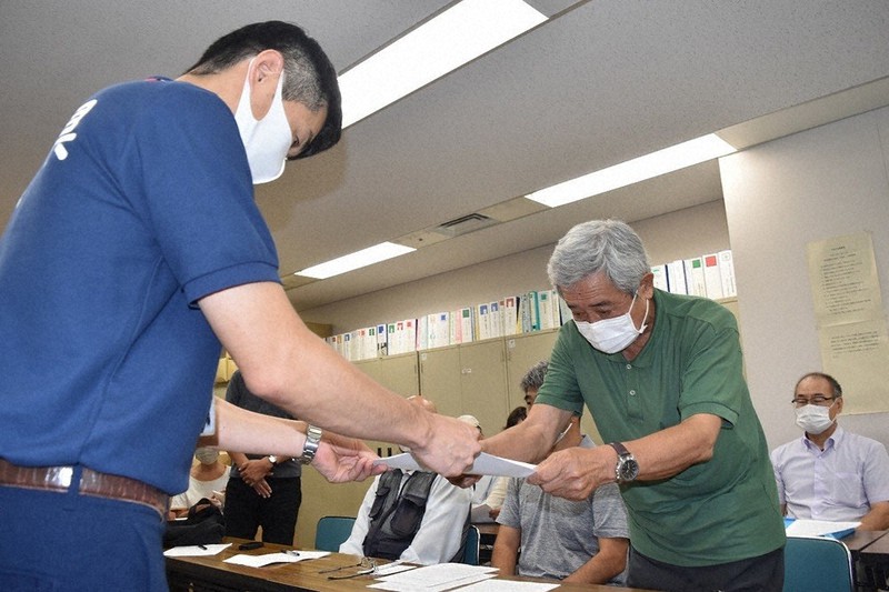 県の担当者(左)に要望書を手渡す市民団体の代表