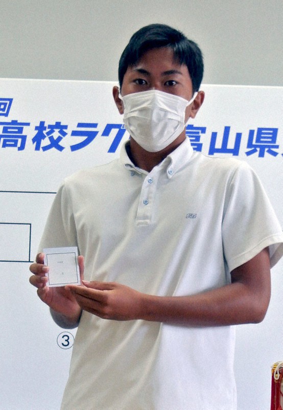 抽選のくじを引く高岡第一の木原陽平主将=富山市新総曲輪の富山県民会館で、青山郁子撮影
